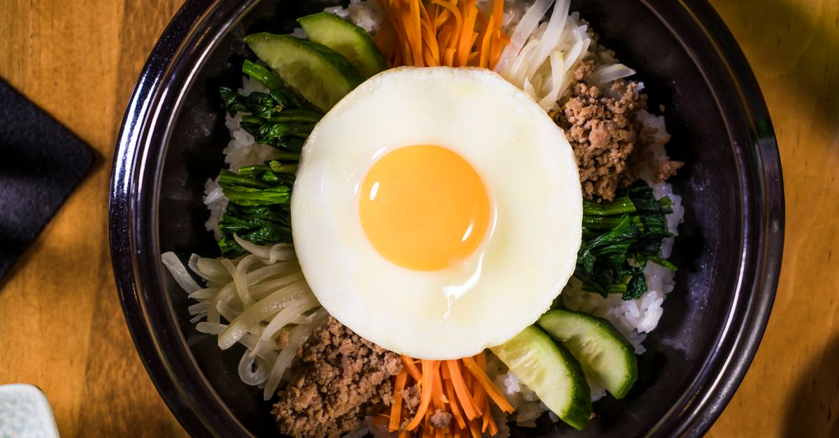 découvrez le bibimbap, plat traditionnel coréen composé de riz, légumes variés, viande et œuf, le tout mélangé avec une sauce épicée pour une explosion de saveurs.